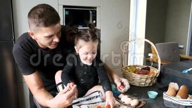 爸爸和小女孩穿着黑色T恤衫在厨房做饭